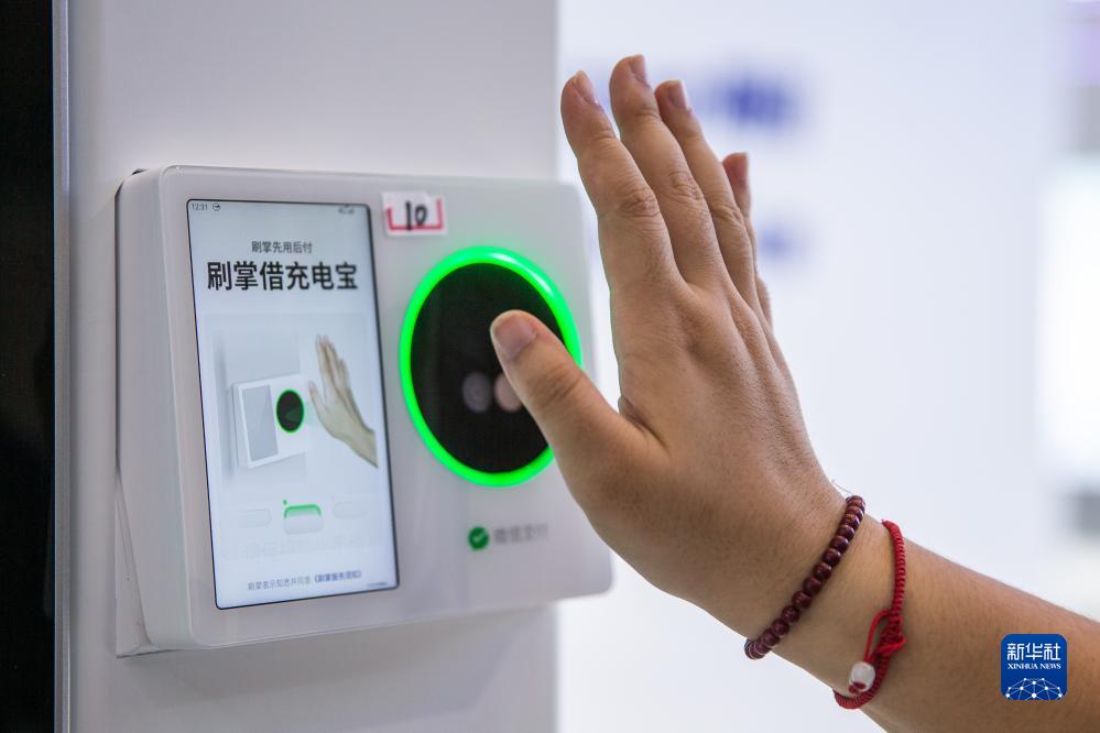 9月4日，在2023智博会腾讯展厅，工作人员演示微信刷掌。新华社记者 储加音 摄